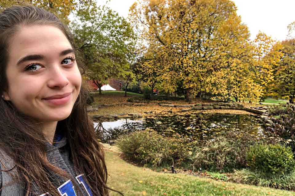 SLU student taking a SLU Koi Pond Selfie 