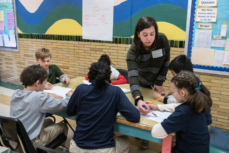 Student teacher and grade-school student work on project