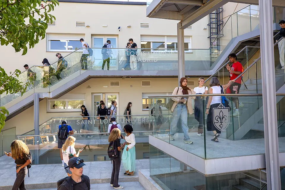 Students walk up and down stairs outdoors on the SLU Madrid campus.