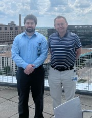 Robert Kousnetsov posing outdoors next to colleague