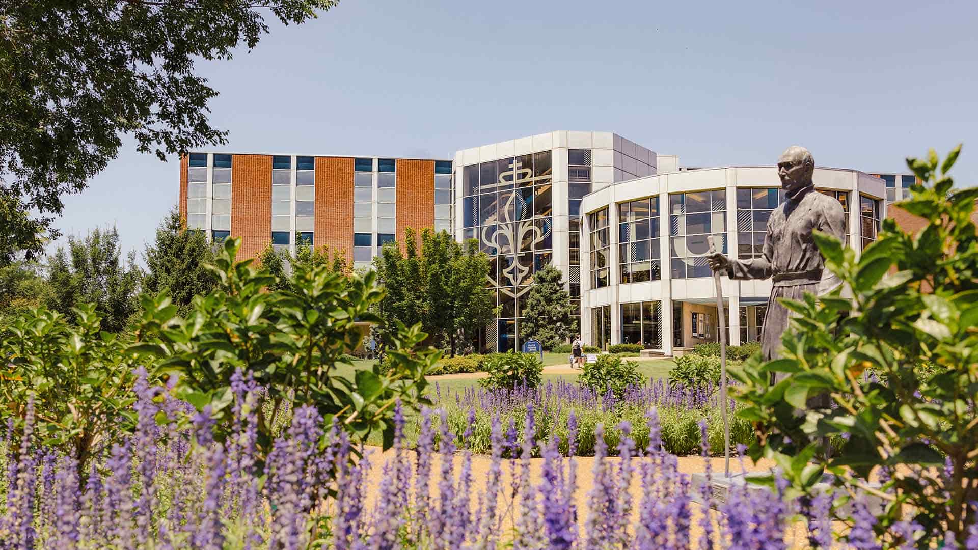 The Pius XII Memorial Library on SLU’s campus with a statue of St. Ignatius in the foreground.