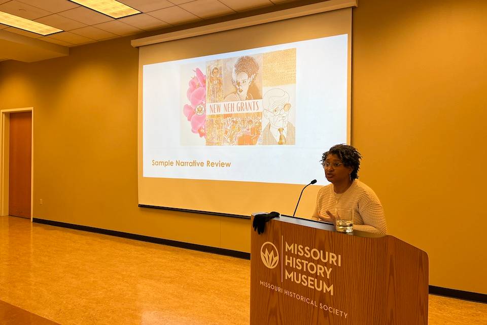 Photo of Laquanda Walters-Cooper of the NEH speaking at a January 2024 workshop held at the Saint Louis Historical Society A speaker stands at a lectern that reads Missouri History Museum, with a projection screen in the background.