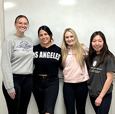 Courtney Castle, Emily Deng, Brooke Hudson and Ivonne Larrea posed against a wall